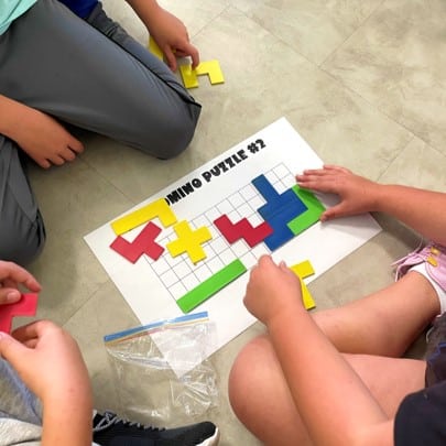 Photo of students completing a pentomino puzzle