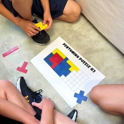 Photo of students completing a pentomino puzzle