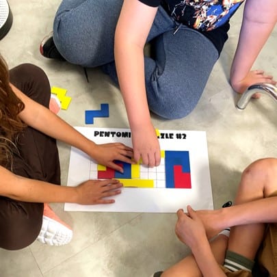 Photo of students completing a pentomino puzzle